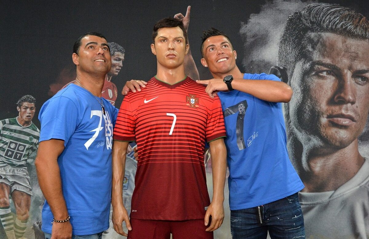Cristiano Ronaldo și fratele său, Hugo Aveiro, cu o statuie de ceară a fotbalistului portughez