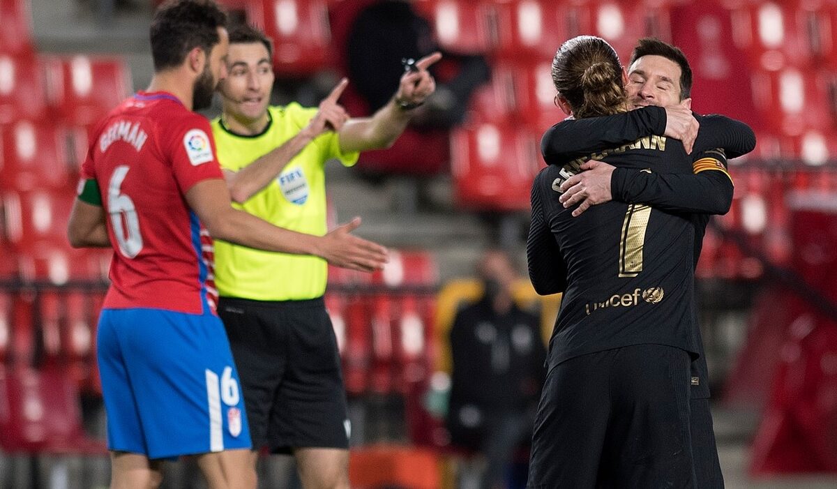 Lionel Messi și Antoine Griezmann se îmbrățișează în timpul unui meci pentru Barcelona