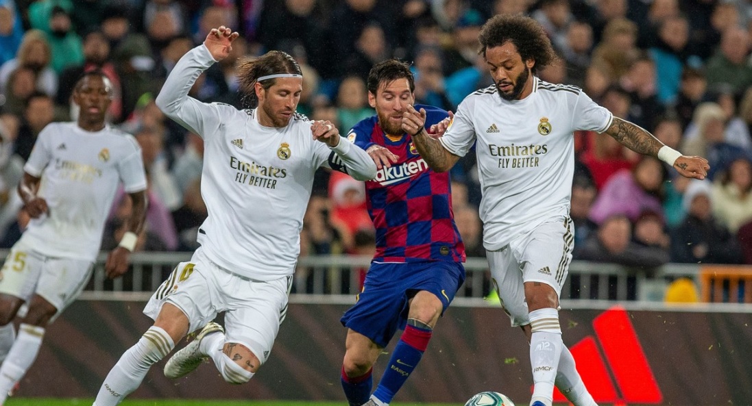 Lionel Messi luptă pentru minge cu Sergio Ramos şi Marcelo