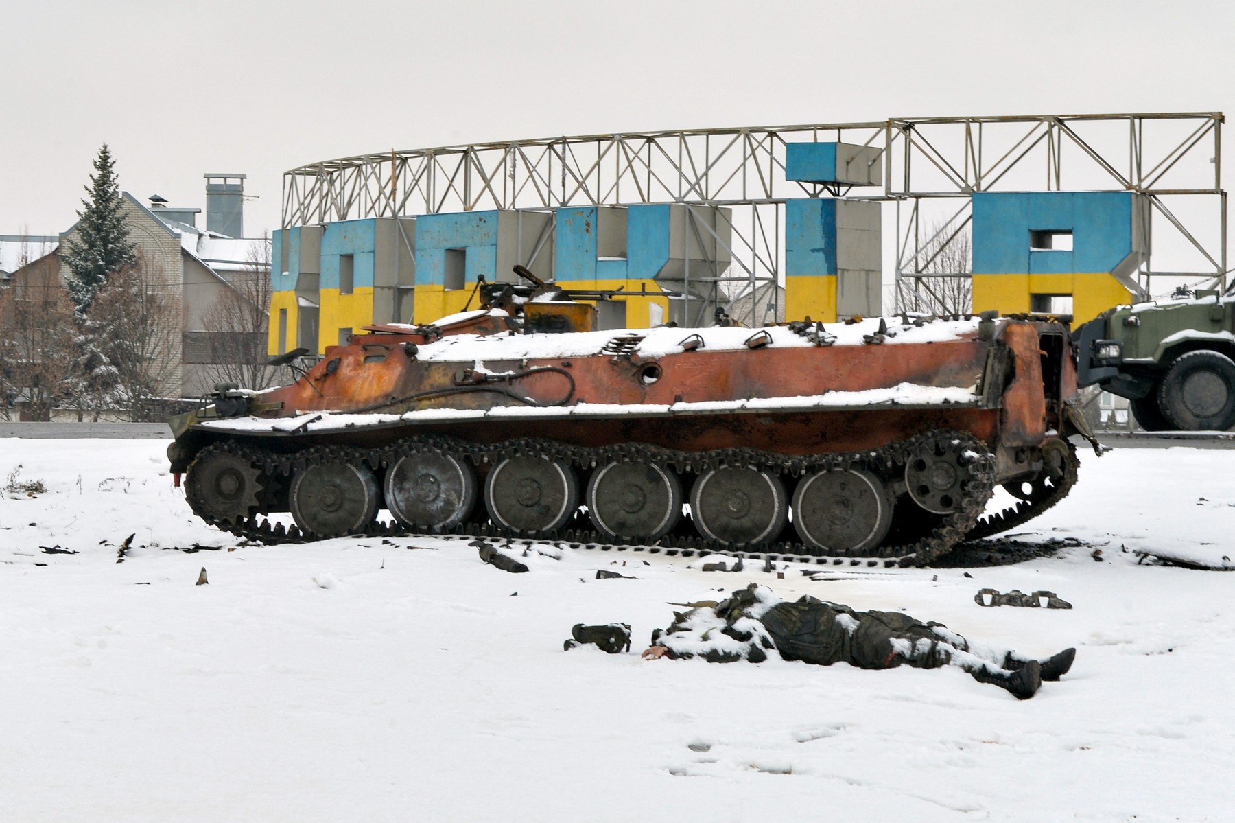 The body of a Russian serviceman lies near destroyed Russian military vehicles on the roadside on the outskirts of Kharkiv on February 26, 2022, following the Russian invasion of Ukraine. Ukrainian forces repulsed a Russian attack on Kyiv but 