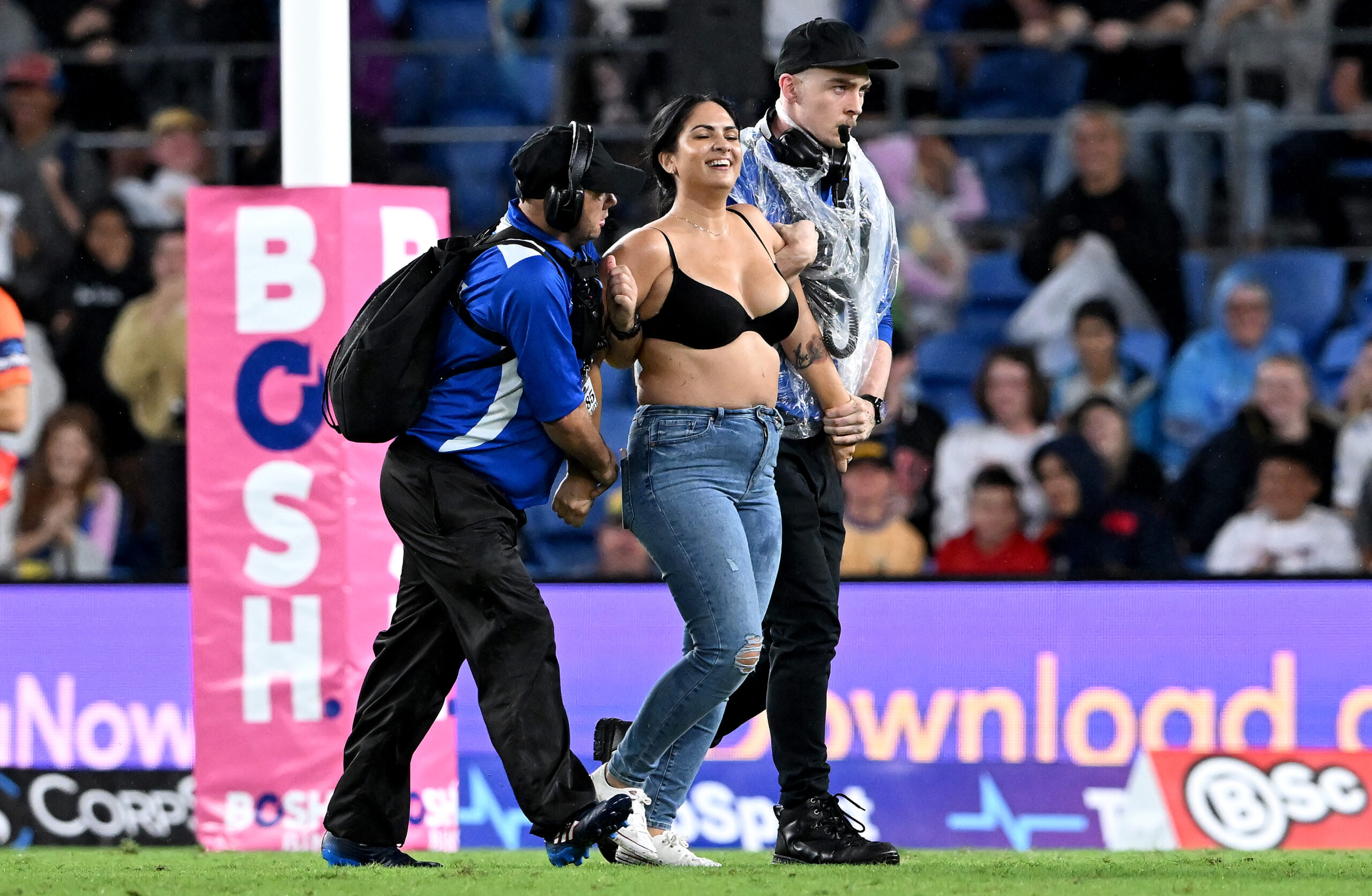 GOLD COAST, AUSTRALIA - APRIL 09: A pitch invader is taken from the field by security guards during the round five NRL match between the Gold Coast Titans and the Parramatta Eels at Cbus Super Stadium, on April 09 2022, in Gold Coast, Australia. (Photo by Bradley Kanaris/Getty Images)