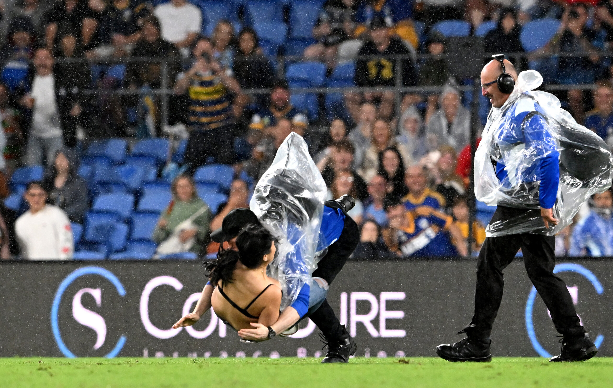 GOLD COAST, AUSTRALIA - APRIL 09: A pitch invader is tackled by a security guard during the round five NRL match between the Gold Coast Titans and the Parramatta Eels at Cbus Super Stadium, on April 09 2022, in Gold Coast, Australia. (Photo by Bradley Kanaris/Getty Images)