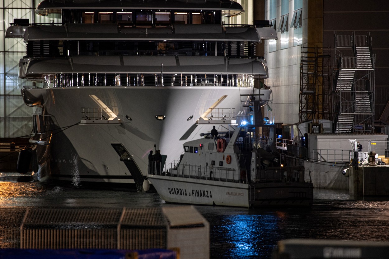 Italy's financial police patrol boat is seen in front of the multi-million-dollar mega yacht Scheherazade, docked at the Tuscan port of Marina di Carrara, Tuscany, on May 6, 2022, after its basin was reflooded.  The mega yacht at the centre of a mystery over its ownership appeared ready to set sail from Italy Friday, as speculation swirls it might belong to the Russian president. 