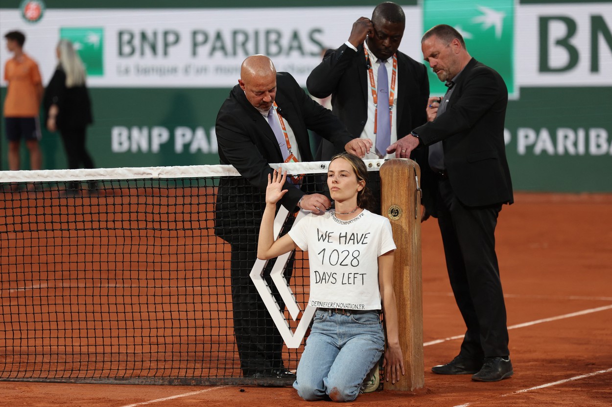 An activist (C) is observed by security personnel after attaching herself to the tennis net during the men's semi-final singles match between Norway's Casper Ruud and Croatia's Marin Cilic on day thirteen of the Roland-Garros Open tennis tournament at the Court Philippe-Chatrier in Paris on June 3, 2022.,Image: 696733511, License: Rights-managed, Restrictions: , Model Release: no, Credit line: Profimedia