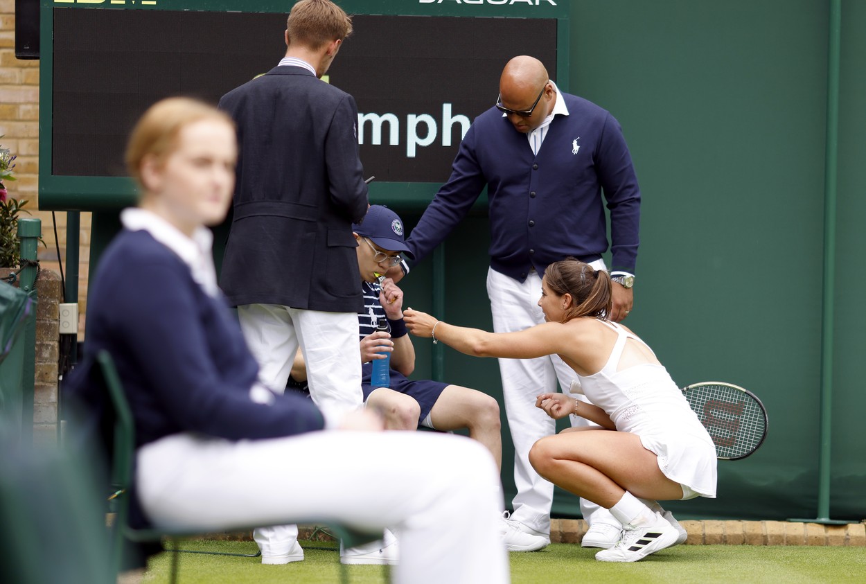 Jodie Burrage helps a ball boy after they fainted during her Ladies' singles first round match against Lesia Tsurenko during day one of the 2022 Wimbledon Championships at the All England Lawn Tennis and Croquet Club, Wimbledon. Picture date: Monday June 27, 2022.,Image: 703167960, License: Rights-managed, Restrictions: Editorial use only. No commercial use without prior written consent of the AELTC. Still image use only - no moving images to emulate broadcast. No superimposing or removal of sponsor/ad logos., Model Release: no, Credit line: Profimedia