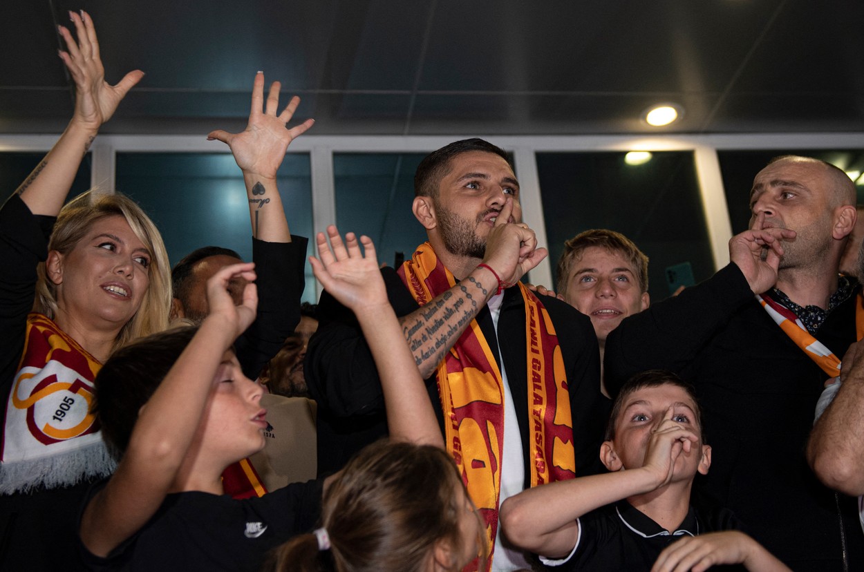 This handout photograph taken and released on September 8, 2022 shows Paris Saint-Germain's Argentinian forward Mauro Icardi (C), next to his wife, Argentinian actress Wanda Nara (L), greeting supporters as he arrives at the Ataturk Airport in Istanbul.,Image: 720535017, License: Rights-managed, Restrictions: RESTRICTED TO EDITORIAL USE - MANDATORY CREDIT 