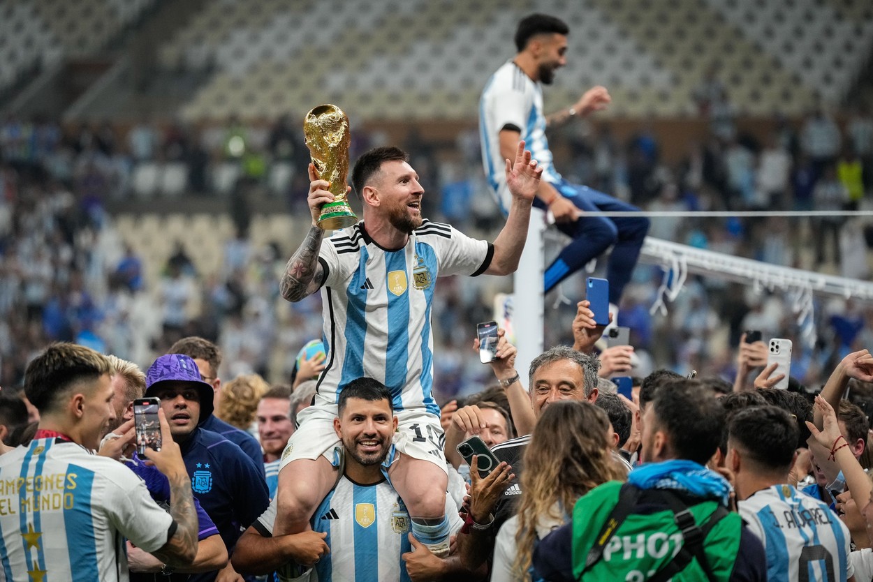 Lionel Messi of Argentina celebrates with the FIFA World Cup trophy on the shoulders of Sergio Aguero as he is surrounded by his teammates, family and friends
Argentina v France, FIFA World Cup 2022, Final, Football, Lusail Stadium, Al Daayen, Qatar - 18 Dec 2022,Image: 745414021, License: Rights-managed, Restrictions: Editorial Use Only, Model Release: no