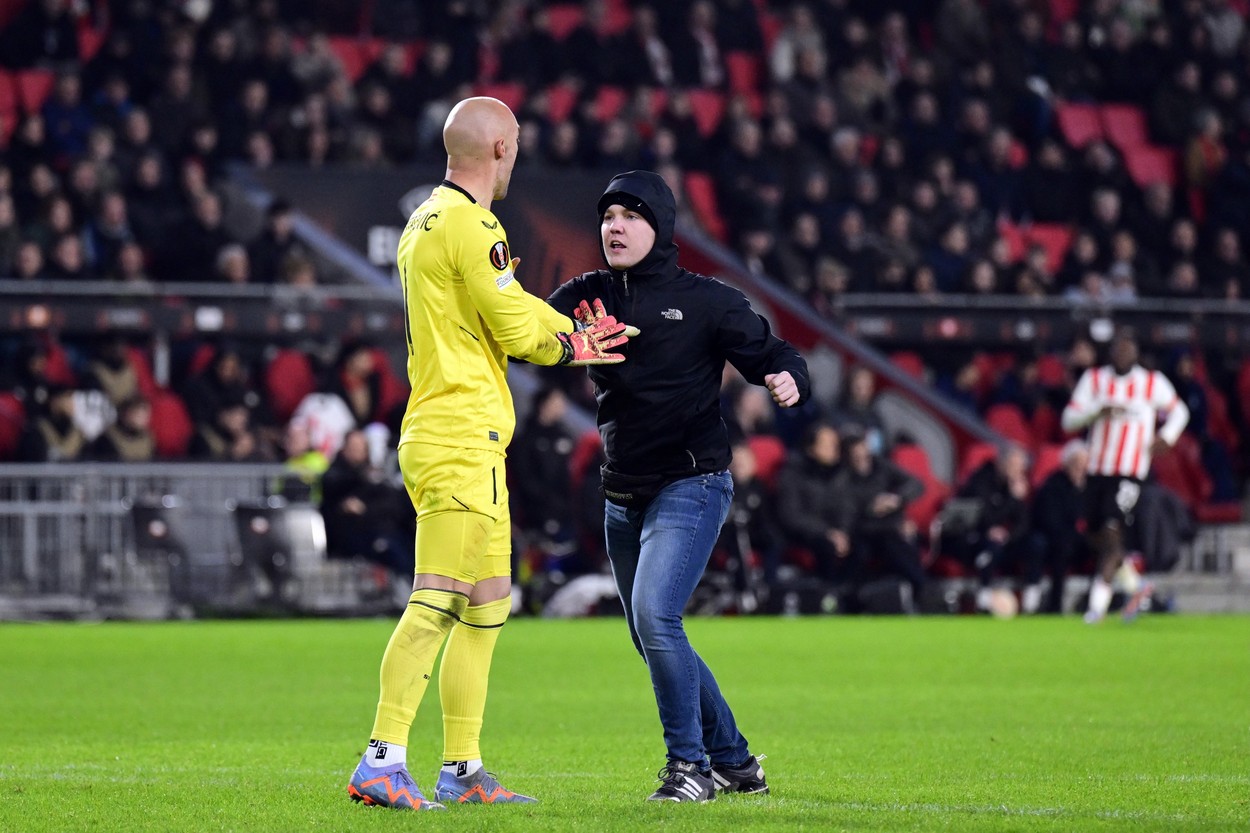 EINDHOVEN - PSV supporter assaults Sevilla FC goalkeeper Marko Dmitrovic during the UEFA Europa league playoff match between PSV Eindhoven and Sevilla FC at Phillips stadium on February 23, 2023 in Eindhoven, Netherlands.
