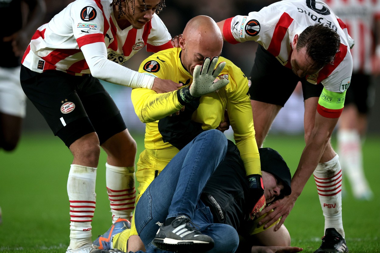 EINDHOVEN - A supporter fights with Sevilla FC goalkeeper Marko Dmitrovic during the UEFA Europa league playoff match between PSV Eindhoven and Sevilla FC at Phillips stadium on February 23, 2023 in Eindhoven, Netherlands.

