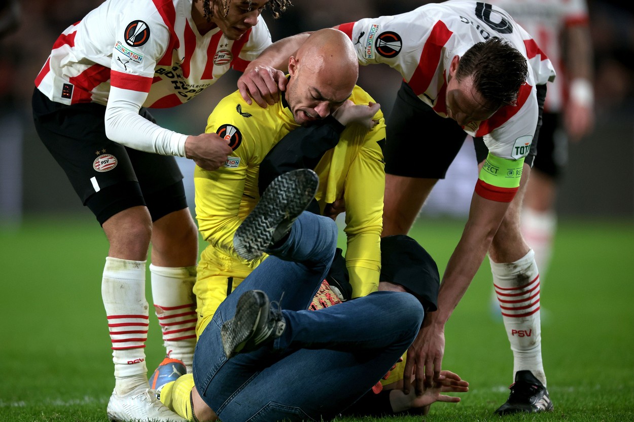 EINDHOVEN - A supporter fights with Sevilla FC goalkeeper Marko Dmitrovic during the UEFA Europa league playoff match between PSV Eindhoven and Sevilla FC at Phillips stadium on February 23, 2023 in Eindhoven, Netherlands.
