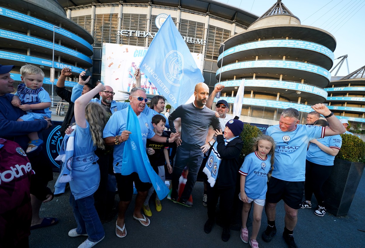 Manchester City fans celebrate with a cardboard cut-out of manager Pep Guardiola outside of the Etihad Stadium after winning the Premier League following the outcome of the Nottingham Forest v Arsenal match. Picture date: Saturday May 20, 2023.,Image: 777746025, License: Rights-managed, Restrictions: , Model Release: no