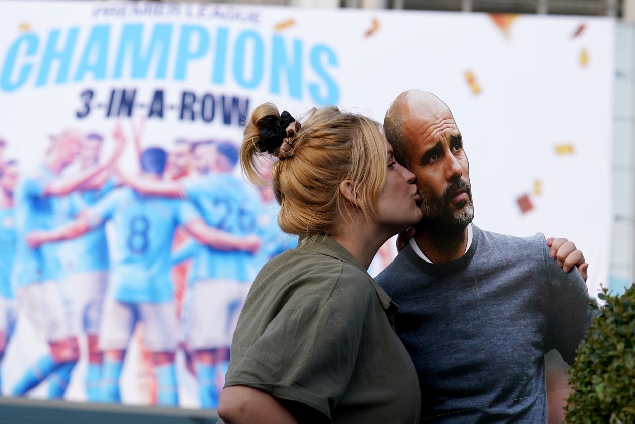 Manchester City fan kisses a cardboard cut-out of manager Pep Guardiola as they celebrate outside of the Etihad Stadium after winning the Premier League following the outcome of the Nottingham Forest v Arsenal match. Picture date: Saturday May 20, 2023.,Image: 777746059, License: Rights-managed, Restrictions: , Model Release: no