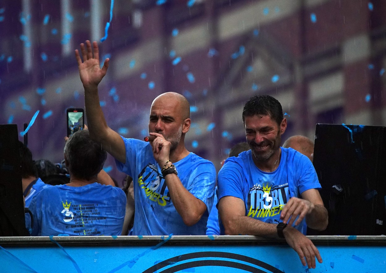 Manchester City manager Pep Guardiola (left) smokes a cigar next to goalkeeping coach Xabier Mancisidor during the Treble Parade in Manchester. Manchester City completed the treble (Champions League, Premier League and FA Cup) after a 1-0 victory over Inter Milan in Istanbul secured them Champions League glory. Picture date: Monday June 12, 2023.,Image: 782976108, License: Rights-managed, Restrictions: Use subject to restrictions. Editorial use only, no commercial use without prior consent from rights holder., Model Release: no