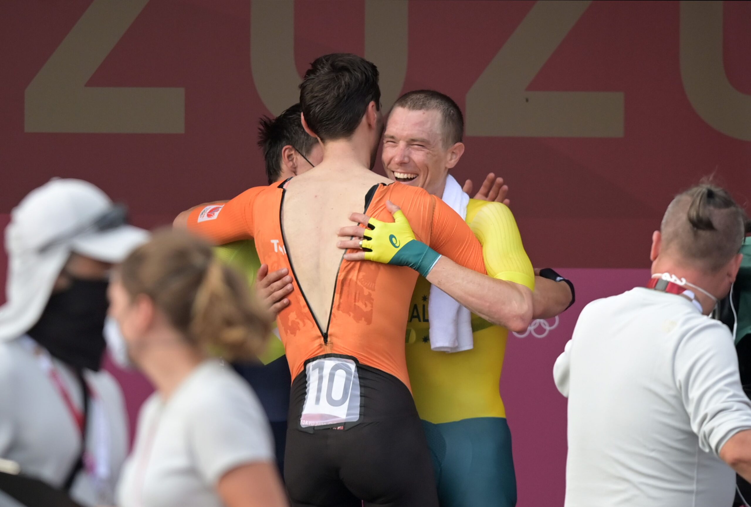 28 July 2021, Japan, Oyama: Slovenia's gold medalist Primoz Roglic (hidden), Netherlands' silver medalist Tom Dumoulin (C) and Australia's bronze medalist Rohan Dennis embrace after the men's Cycling Individual Time Trial, 44.20km at Fuji International Speedway, during the Tokyo 2020 Olympic Games. Photo: Sebastian Gollnow/dpa