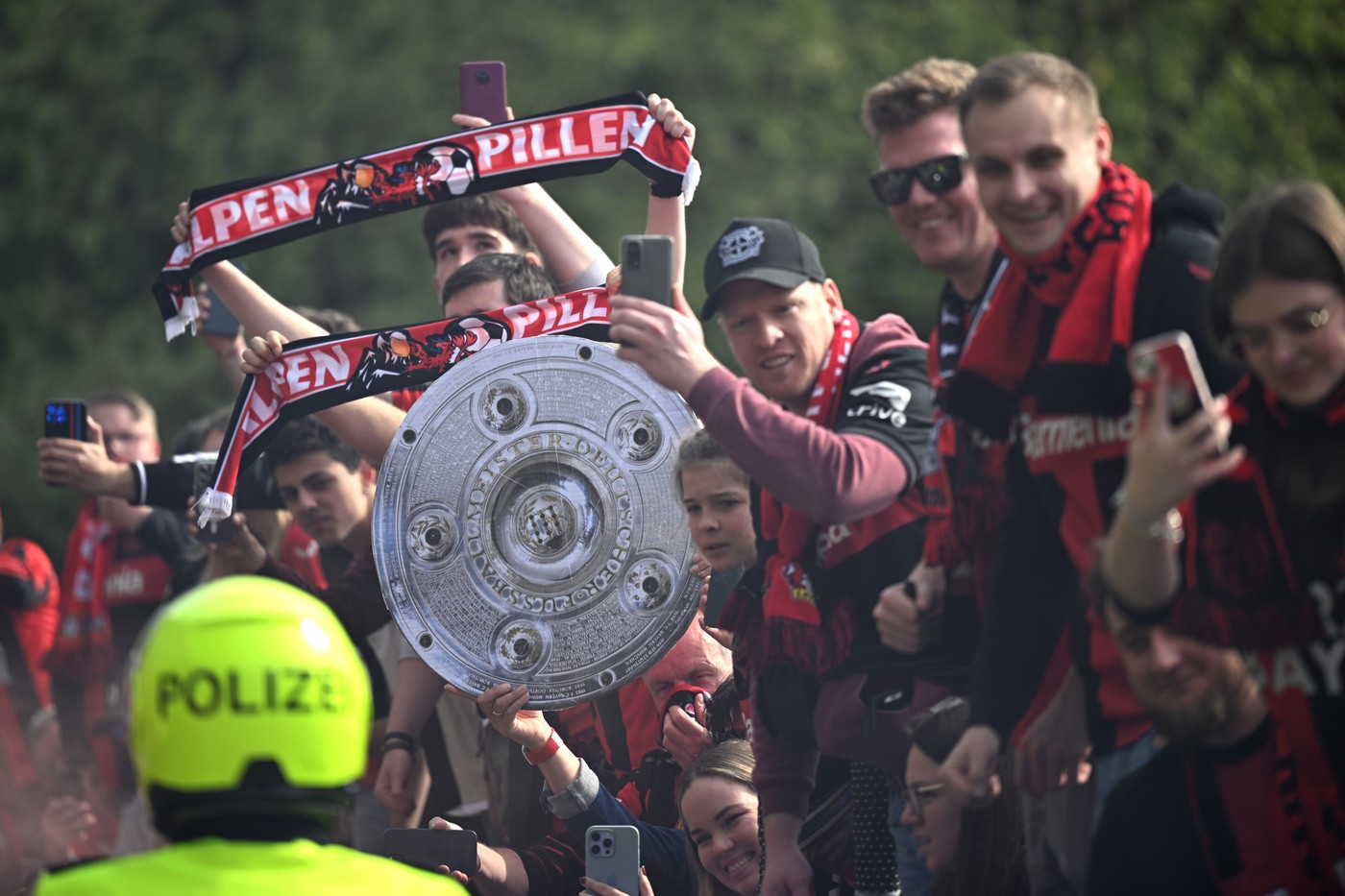 14 April 2024, North Rhine-Westphalia, Leverkusen: Soccer, Bundesliga, Bayer 04 Leverkusen - SV Werder Bremen, Matchday 29, BayArena. Leverkusen fans with a stylized championship trophy welcome the team bus and create a great atmosphere before the game.,Image: 864748732, License: Rights-managed, Restrictions: , Model Release: no