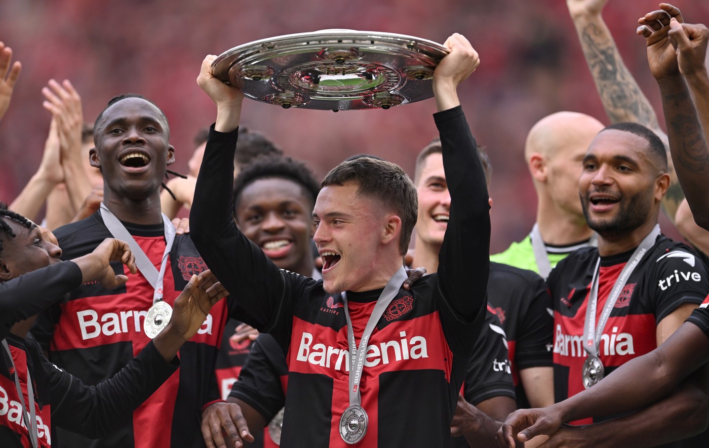 18 May 2024, North Rhine-Westphalia, Leverkusen: Soccer, Bundesliga, Bayer Leverkusen - FC Augsburg, Matchday 34, BayArena, Leverkusen's Florian Wirtz celebrates with the championship trophy. IMPORTANT NOTE: In accordance with the regulations of the DFL German Football League and the DFB German Football Association, it is prohibited to use or have used photographs taken in the stadium and/or of the match in the form of sequential images and/or video-like photo series.,Image: 874180051, License: Rights-managed, Restrictions: , Model Release: no