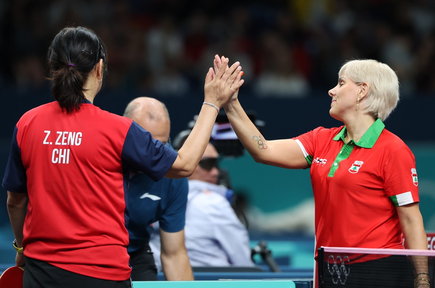 PARIS, July 27, 2024  -- Zeng Zhiying (L) of Chile interacts with Mariana Sahakian of Lebanon after their women's singles preliminary round table tennis match at the Paris 2024 Olympic Games in Paris, France, on July 27, 2024.,Image: 893131969, License: Rights-managed, Restrictions: , Model Release: no