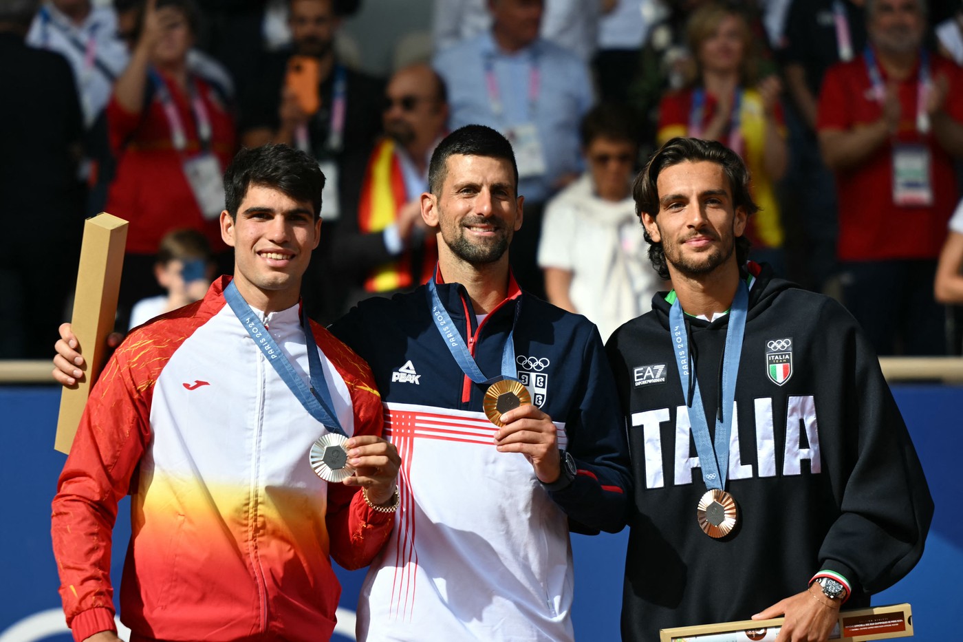 (L-R) Silver medallist Spain's Carlos Alcaraz, gold medallist, Serbia's Novak Djokovic and bronze medallist Italy's Lorenzo Musetti pose with their medals on the podium at the presentation ceremony for the men's singles tennis event on Court Philippe-Chatrier at the Roland-Garros Stadium during the Paris 2024 Olympic Games, in Paris on August 4, 2024.,Image: 895910022, License: Rights-managed, Restrictions: , Model Release: no
