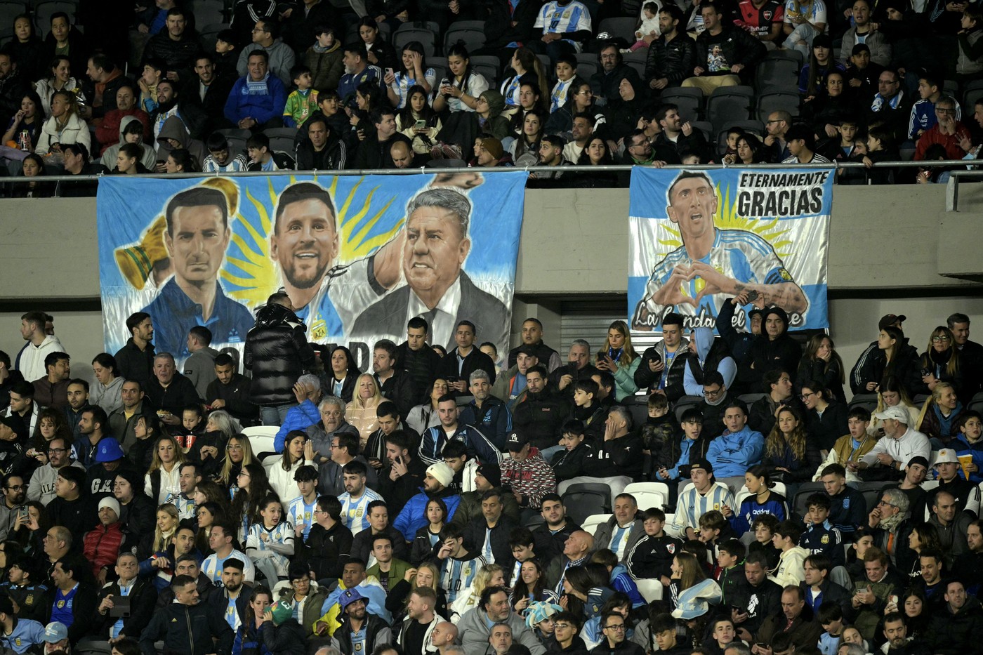 A banner with the image of Argentine national team coach Lionel Scaloni (L), Argentine striker Lionel Messi (C), and the president of the Argentine Football Association (AFA), Claudio Tapia, is seen next to another with the image of Argentina's midfielder Angel Di Maria during a tribute following Di Maria's retirement from the Argentina national team before the 2026 FIFA World Cup South American qualifiers football match between Argentina and Chile at the Mas Monumental stadium in Buenos Aires on September 5, 2024.,Image: 905144232, License: Rights-managed, Restrictions: , Model Release: no