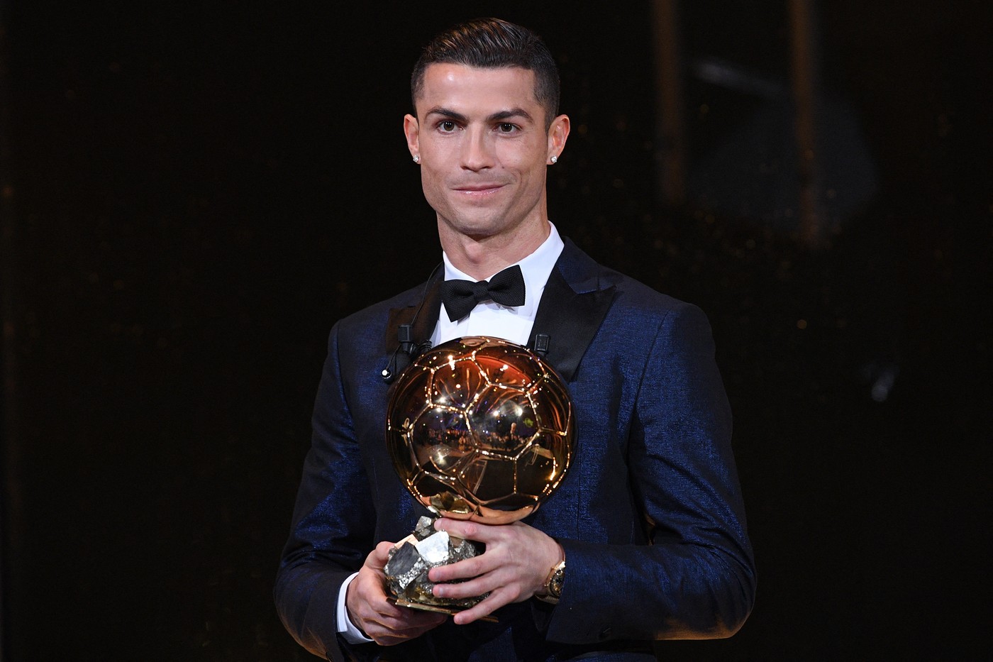 This handout photo released on December 7, 2017 by L'Equipe shows Portugese player Cristiano Ronaldo posing with the 2017 Ballon d'Or France Football trophy in Paris. Portuguese star Cristiano Ronaldo won a record-equalling fifth Ballon d'Or (2008, 2013, 2015, 2016 and 2017) award for the year's best player on December 7. The Real Madrid forward's second successive win draws him level alongside Barcelona rival Lionel Messi on five Ballon d'Ors, after beating the Argentinian and Brazilian Neymar.,Image: 357186488, License: Rights-managed, Restrictions: RESTRICTED TO EDITORIAL USE - MANDATORY CREDIT 